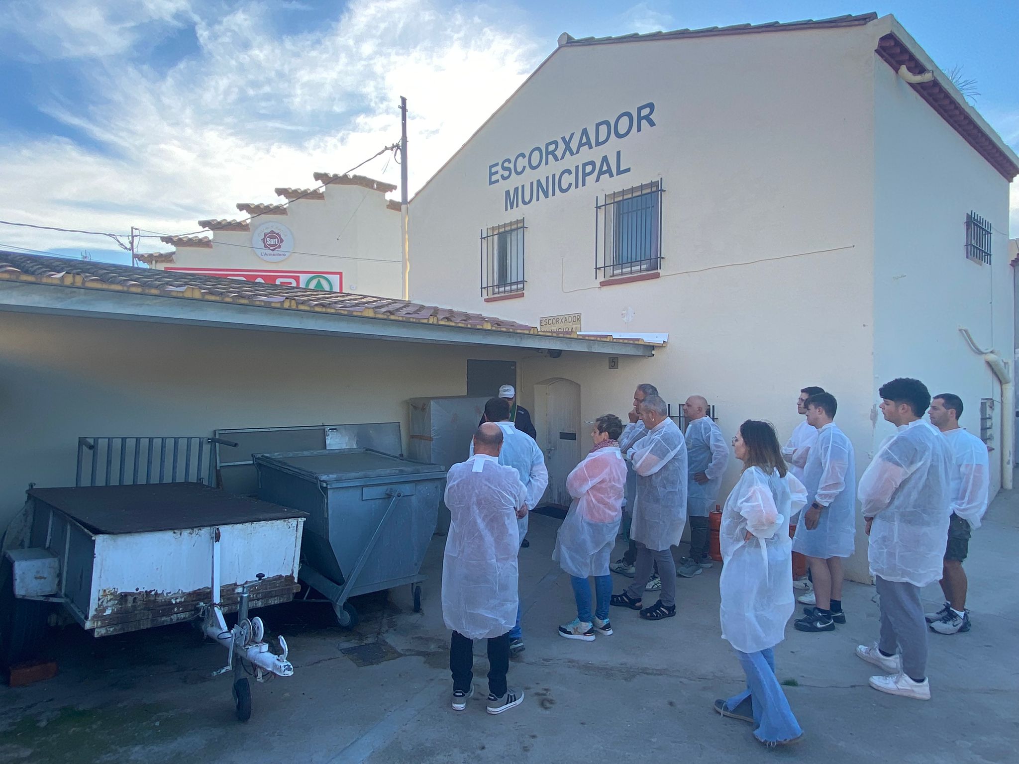 Visitors in protective clothing outside the Escorxador Municipal de l’Armentera